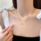 Gold-tone double-ring pendant necklace worn at the collarbone