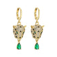 Gold-tone leopard head huggie earrings with emerald-green teardrop pendants on a white backdrop