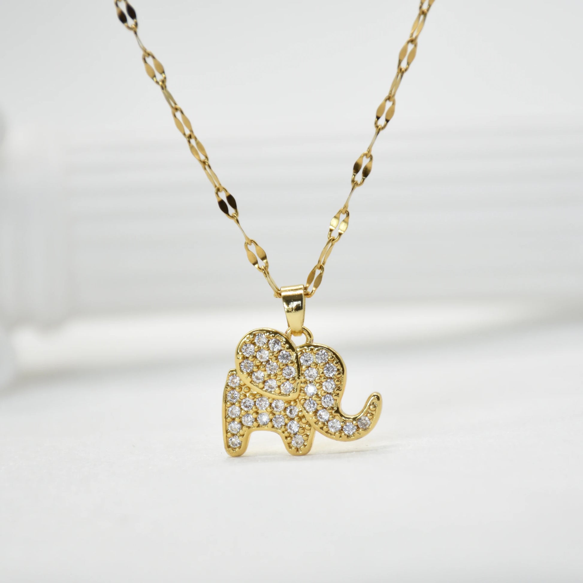Gold-tone elephant pendant necklace with clear pavé stones on patterned chain