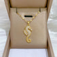 Gold-tone butterfly pendant necklace with clear stones and two dangling bars on a fine chain, displayed on a jewelry box.