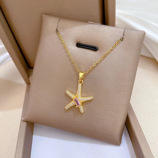 Gold-tone starfish pendant necklace on tan jewelry display cushion