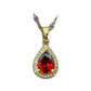 Gold-tone teardrop pendant necklace with red center resting on a cushioned display box