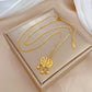Gold-tone necklace with filigree medallion pendant and three small dangling beads, shown with lobster clasp and extender
