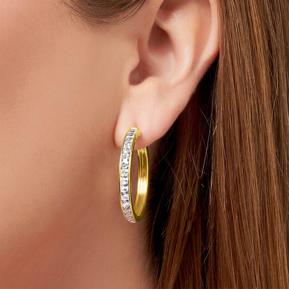 Single gold-tone hinged hoop with clear stones worn at the earlobe